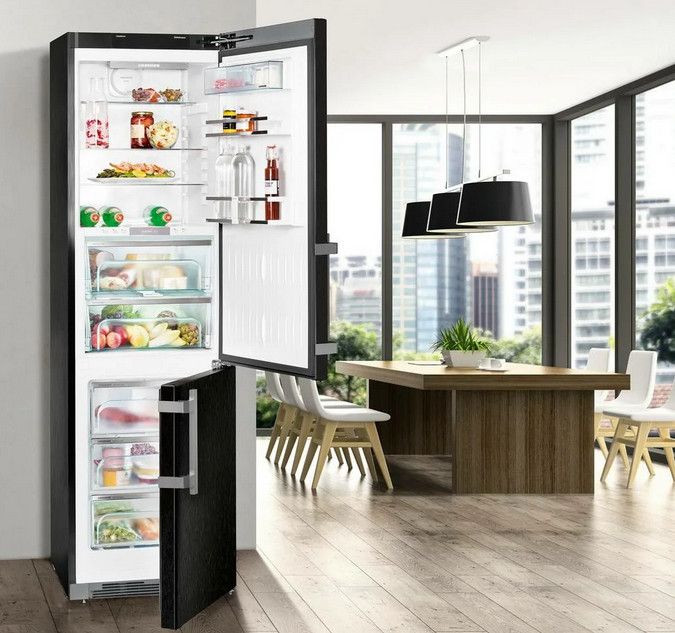 Открытый холодильник стоит на кухне